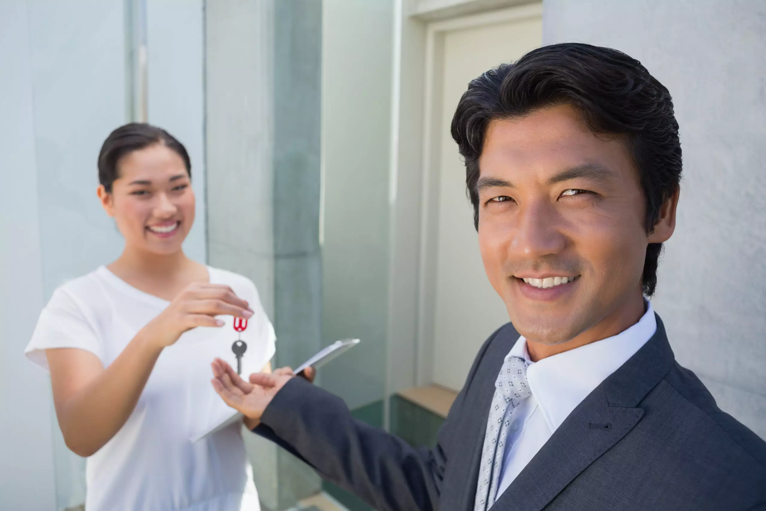 realtor handing keys to woman